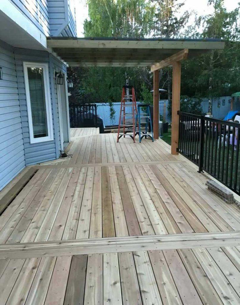 a backyard deck with a pergola made out of wood