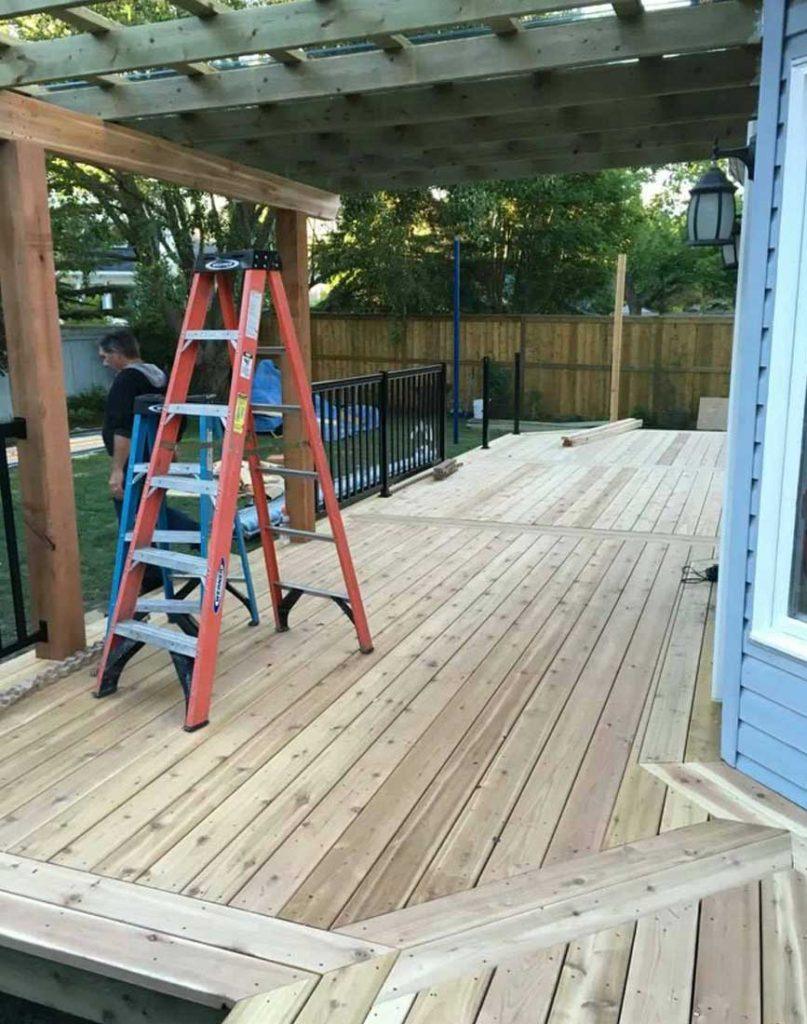 a backyard deck with a pergola made out of wood