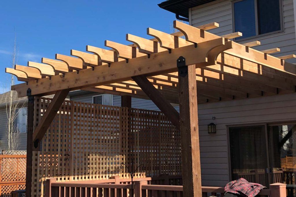 a wooden pergola in a backyard