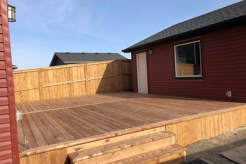 an exterior photo of the back of a house looking at a wooden deck