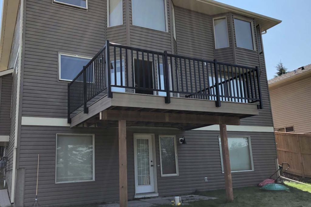 a raised second floor deck, attached to the back of a house