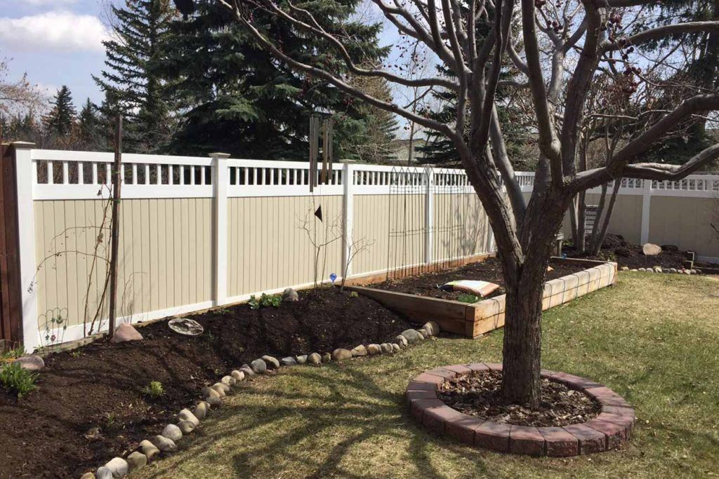 a tree with a white and beige outdoor fence