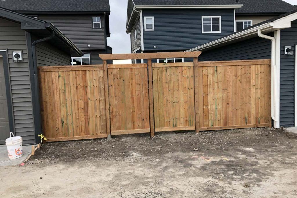 two wooden gates between to houses