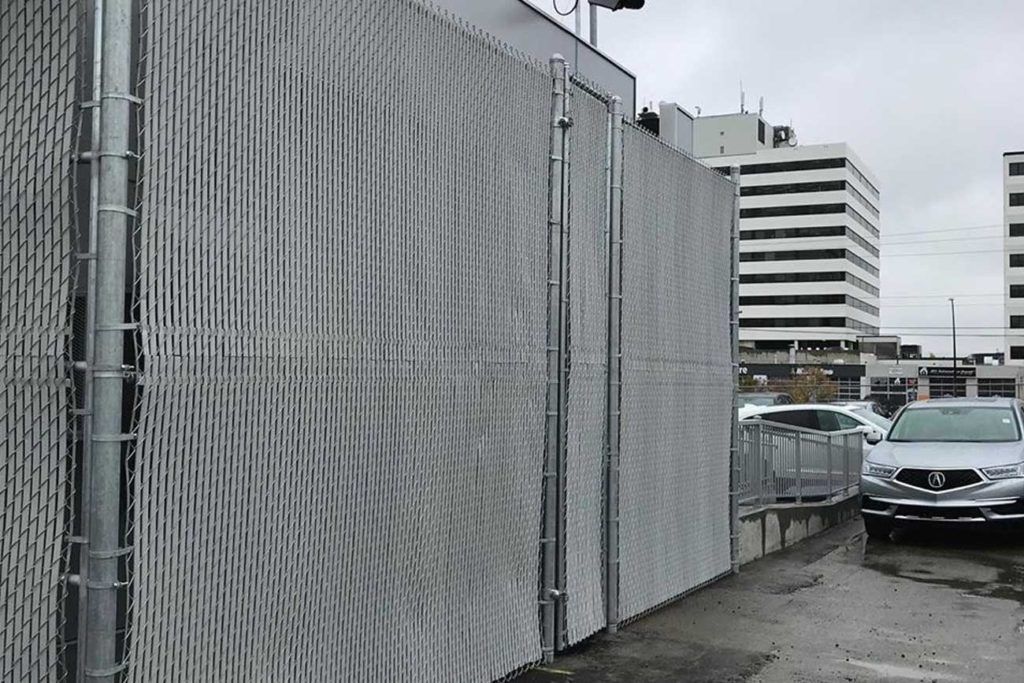 a chain link fence in an industrial parking lot